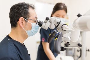 マイクロスコープを使用する歯科医師